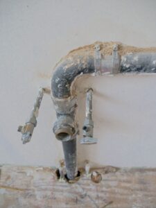 Plumber inspecting a pipe for a sewage backup insurance California claim