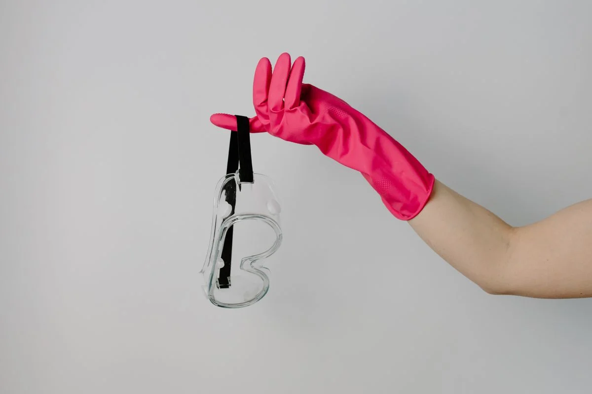 Restoration technician in protective gear cleaning smoke residue from a wall during a wildfire smoke damage restoration project