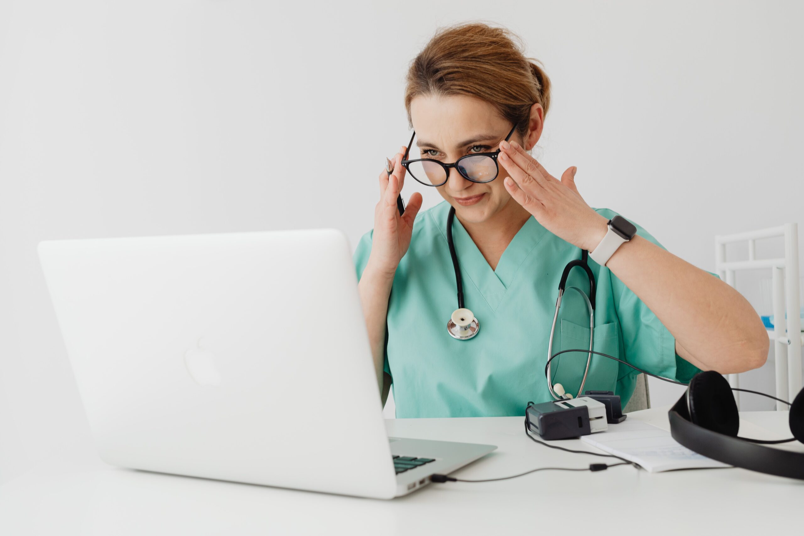 Medical professional conducting a virtual consultation on a laptop, illustrating how AI search and GEO differ from traditional medical SEO