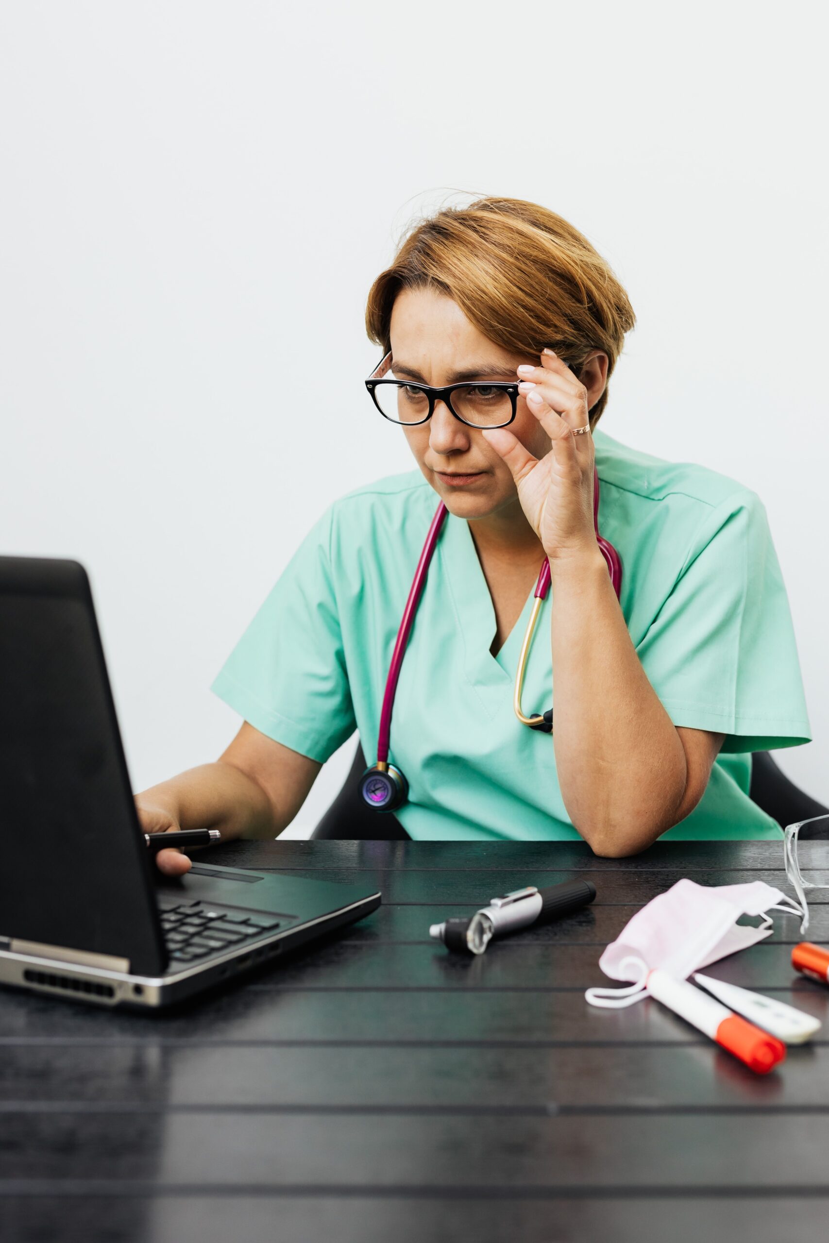 Doctor working intently at a desk on a laptop, representing the practical steps a medical practice takes to improve AI search visibility