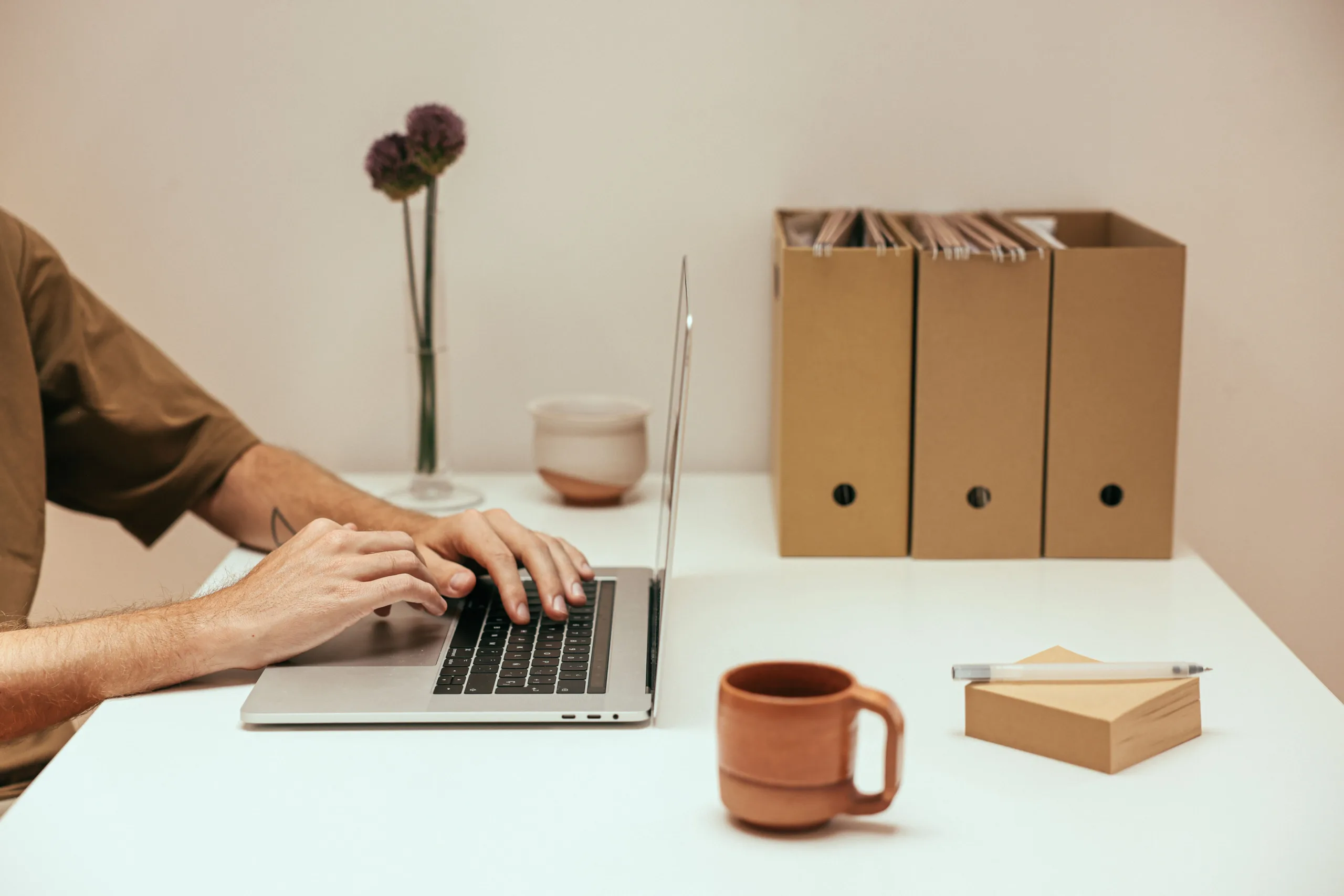 Google AI Mode Ads for Healthcare: What Changed in 2026 2 Person typing on a laptop at a clean office desk while reviewing marketing campaign work